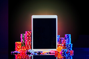 Sticker - A gaming tablet surrounded by colorful poker chips at a casino table during a night gambling session