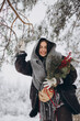 © anatoliycherkas - Portrait of happy pretty woman holding winter pine bouquet and posing in snowy forest