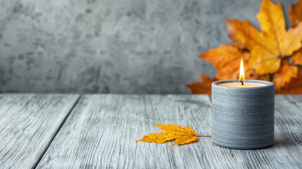 Poster - Burning grey candle on empty table with autumn leaves decoration