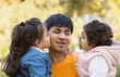 © VictorCanalesStudio - Headshot of happy hispanic family of father with two kids outdoors. Son is kissing his lovely daddy