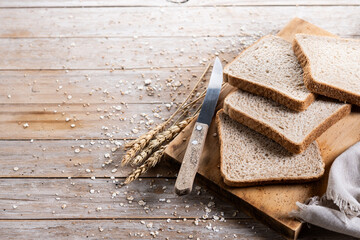 Healthy wholemeal bread slices on wooden table. Copy space