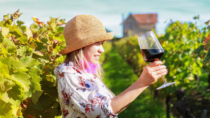 Wall Mural - Asian young woman  with  wine glass tasting in vineyard during the evening sky scene -Bordeaux france.