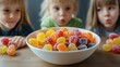 © TENGKUIZAHAM - Three children looking at a bowl full of candy