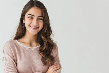 Poster - Smiling young female model with crossed arms, isolated on a white setting , background blur