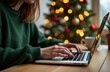 © Ekaterina - The hands of a young woman working at home on a computer during the Christmas holidays. Working online during the holidays