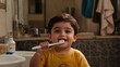 © Vasyl - A cheerful Indian boy enjoys brushing his teeth in a bright yellow T-shirt against a tiled bathroom backdrop