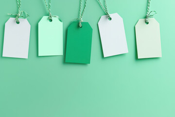 Poster - Five colorful blank gift tags hanging on a green background for seasonal sale