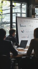 Poster - A team engaged in a business meeting, analyzing charts and graphs displayed on a large screen in a modern office setting.
