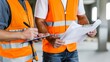© Ekkarat_Studio - Construction workers reviewing plans on site