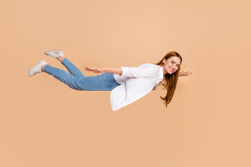 Wall Mural - Full length photo of satisfied lovely woman dressed cardigan denim trousers flying to sale empty space isolated on beige color background