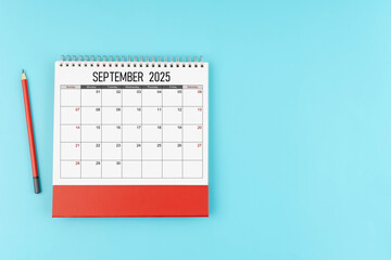 September desk calendar for 2025 year with pencil on blue background, Position with copy space.