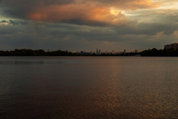 Wall Mural - Bright sunset over lake, golden clouds reflect in the water