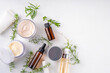 © ricka_kinamoto - Clean beauty, eco organic natural cosmetics. Set of various cream, serum, moisturizing skincare cosmetics with green herbal leaves and sprigs, on white background copy space