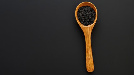 Black sesame seeds in a wooden spoon against a dark background, showcasing their natural texture and rich color, ideal for culinary, health, and ingredient concepts