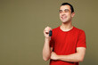 © ViDi Studio - Young happy middle eastern man wear red t-shirt casual clothes hold in hand car key fob keyless system look aside on area isolated on plain pastel green background studio portrait. Lifestyle concept.