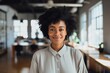 © Baba Images - Smiling portrait of a young hipster African American woman in office
