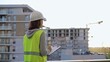 © volha_r - Woman engineer with a hard hat and safety vest is writing on a clipboard while inspecting a construction site at sunset