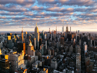 An aerial photo of Manhattan's upper downtown from above during the sunrise clouds in the background. New York, USA