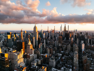 an aerial photo of manhattan's upper downtown from above during the sunrise clouds in the background