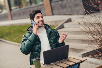 Sticker - Photo of positive nice man sitting on cafe terrace outdoors speaking phone enjoying weekend day outdoors