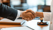 © Maksym - A lawyer shakes hands with her client in a high-end legal office, with a symbolic gavel and law books prominently displayed in the background, emphasizing trust and legal expertise