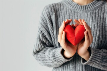 Wall Mural - A woman holds a red heart in her hands