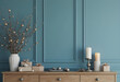© PTD - minimalist Christmas interior featuring wooden dresser adorned with decorative candles, gifts, and stylish vase with branches. serene blue wall adds calming touch