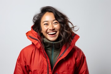 Poster - Portrait of a cheerful asian woman in her 30s donning a durable down jacket over white background