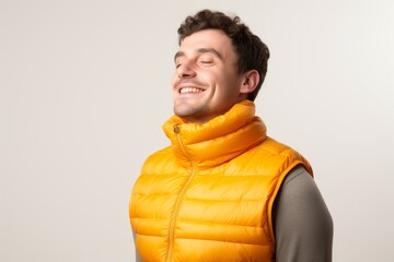 Poster - Portrait of a blissful man in his 30s dressed in a thermal insulation vest in white background