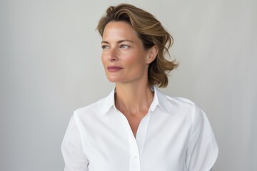 Poster - Portrait of a tender woman in her 40s wearing a classic white shirt on white background