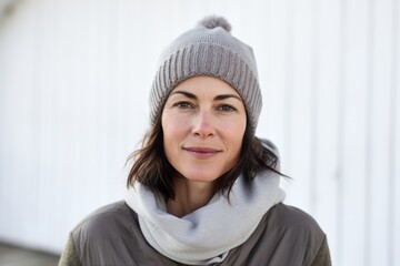 Sticker - Portrait of a tender woman in her 40s donning a warm wool beanie over white background