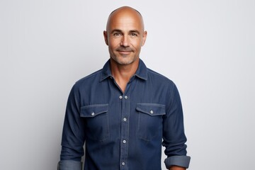 Wall Mural - Portrait of a content man in his 40s sporting a versatile denim shirt over white background