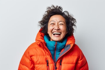 Wall Mural - Portrait of a grinning asian woman in her 50s donning a durable down jacket isolated in white background