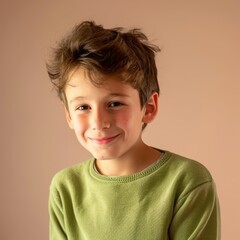 a cheerful young italian boy in a green sweater smiles warmly against a simple background.