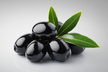 Sticker - A collection of black olives surrounded by leaves on a white surface