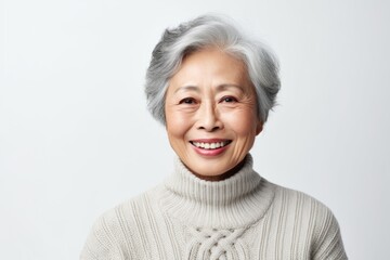 Wall Mural - Portrait of a smiling asian woman in her 80s wearing a classic turtleneck sweater isolated in white background