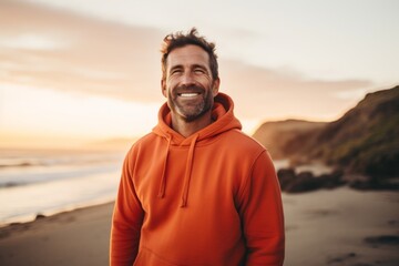 Wall Mural - Portrait of a smiling man in his 40s wearing a thermal fleece pullover in front of beautiful beach sunset