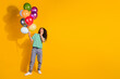 © deagreez - Full size photo of pretty young girl balloons empty space wear striped t-shirt isolated on yellow color background