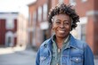 © Markus Schröder - Portrait of a grinning afro-american woman in her 60s wearing a rugged jean vest isolated in charming small town main street