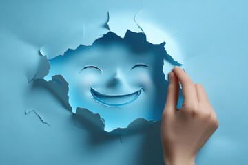 Poster - A person's hand holds a cut-out paper with a smiling face, perfect for illustration or design