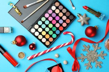 Poster - Different decorative cosmetic products and Christmas decor on light blue background, flat lay