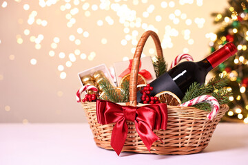 Canvas Print - Wicker gift basket with wine and Christmas decor on light table, space for text