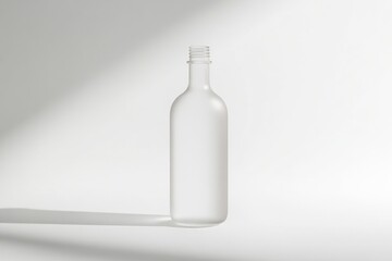 Poster - A clear glass water bottle sits on a clean white surface, waiting for use