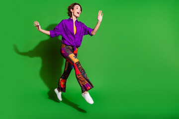 Poster - Full length photo of young hipster girl wearing old school style clothing jump running looking far away isolated on green color background