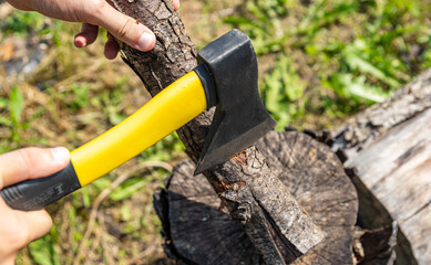 Steel axe, metal ax for wood chopping. Man holding heavy ax. Axe in lumberjack hands chopping or cutting wood trunks.