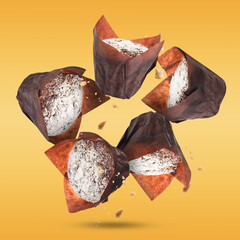 Poster - Delicious muffins with powdered sugar falling on golden background