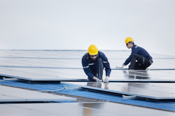 Engineers checking on solar panel on the factory rooftop
