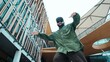 © InfiniteFlow - Low angle view of hipster pose in hip hop style surrounded by mall view. Portrait of sporty asian hip hop choreographer dancing break dance while looking at camera. Outdoor sport 2024. Hiphop.