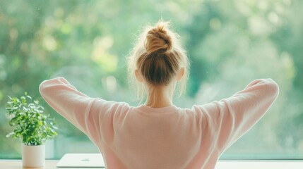 Sticker - A young woman in a comfortable outfit takes a break from working on her laptop, stretching her arms and enjoying the view from her home office window.