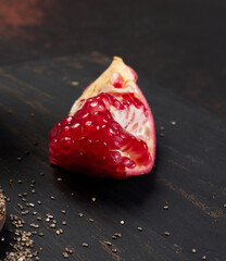 Wall Mural - A piece of pomegranate with red seeds on the table